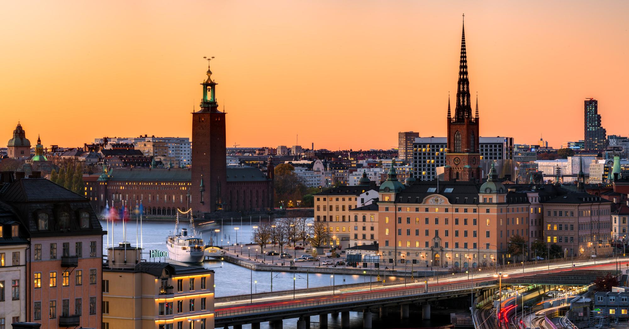 Stockholms stadssiluett i solnedgång med Stadshuset och Riddarholmskyrkan